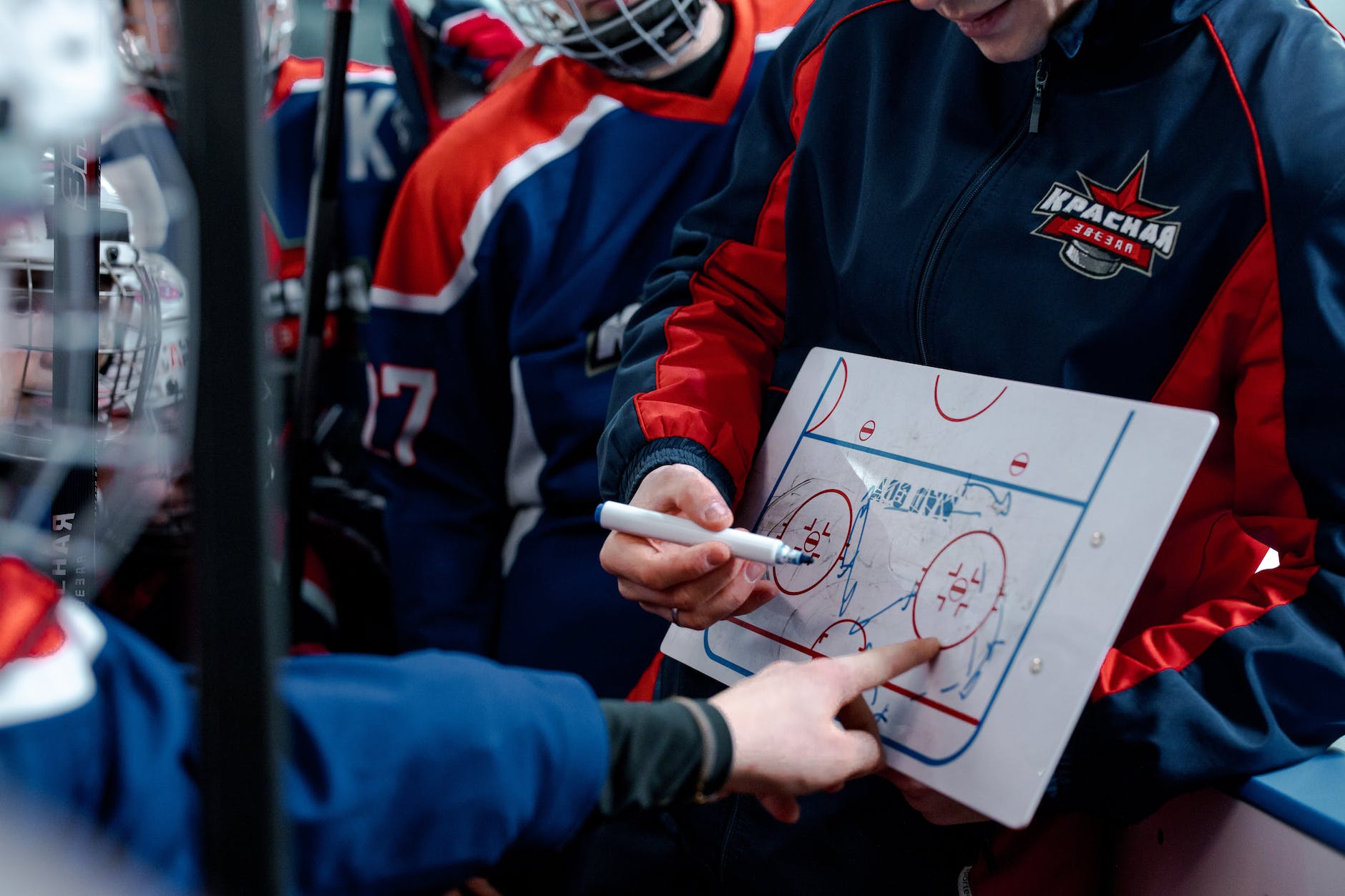 a hockey coach explaining on a coaching board